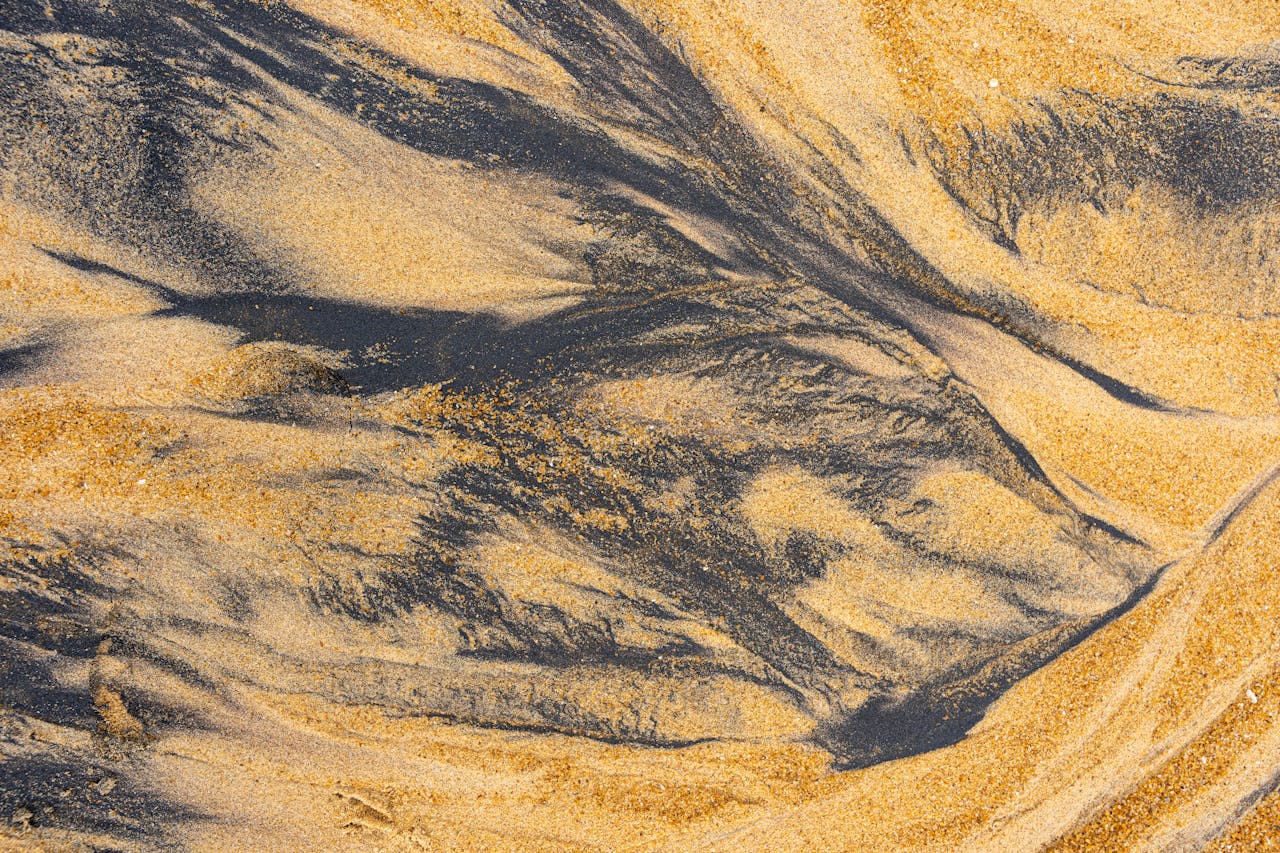 Crafting Captivating Headlines: Your awesome post title goes here Top view of ilmenite and sand textures creating natural patterns on a beach.